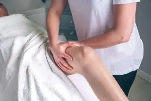 Therapist doing lymphatic drainage on clients leg.