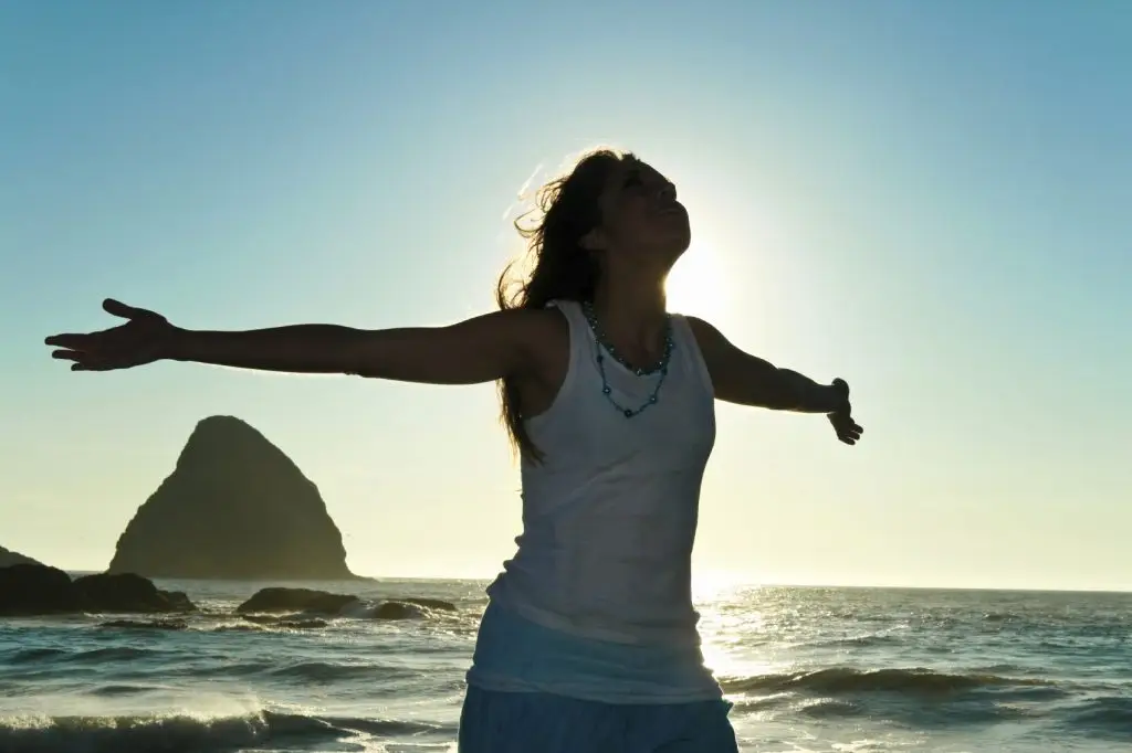woman with open arms at the ocean